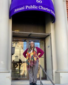 Debra Stern, Executive Director of Amani Public Charter School in front of school building.